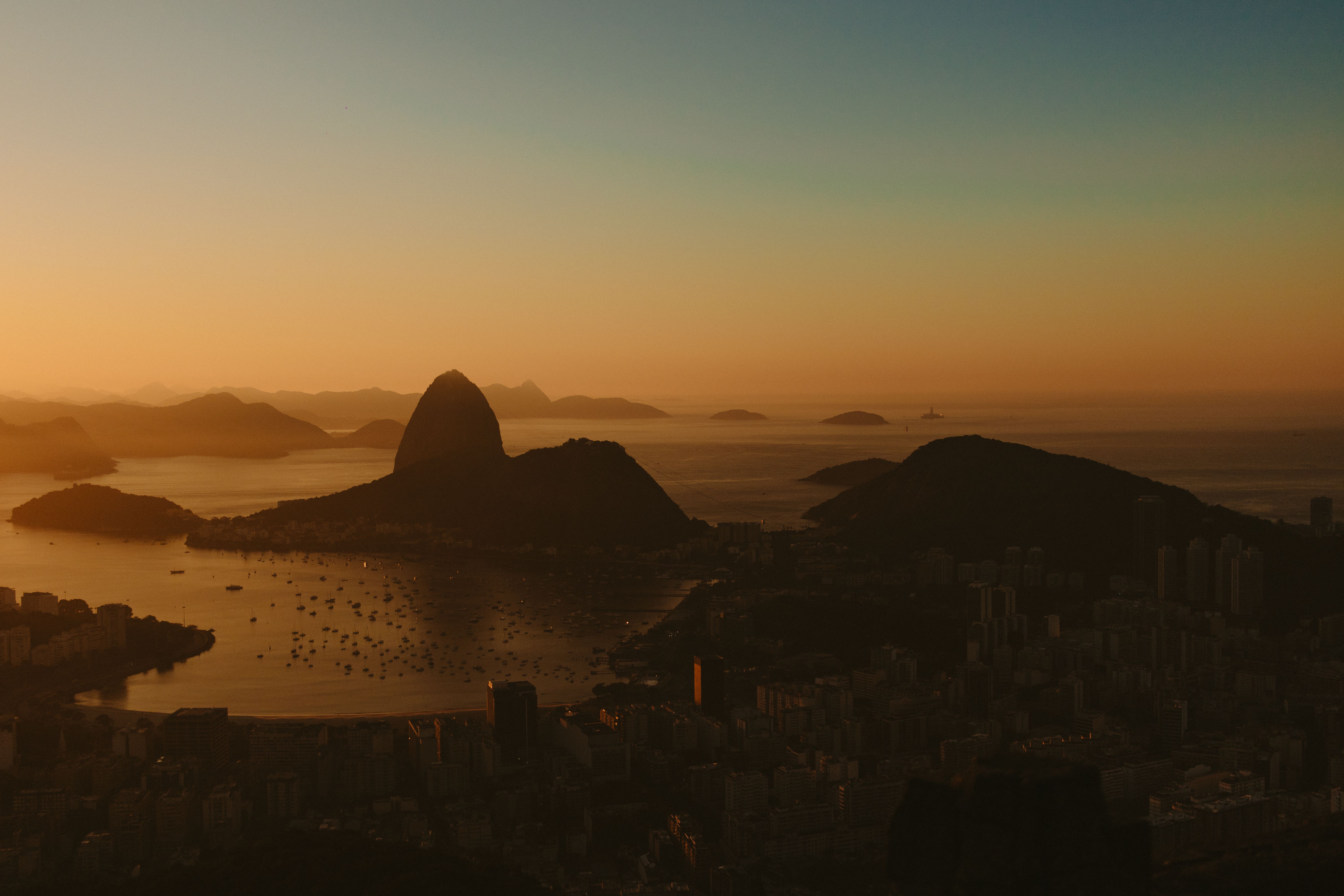 Coastal mountains, islands, and city rooftops at golden sunset